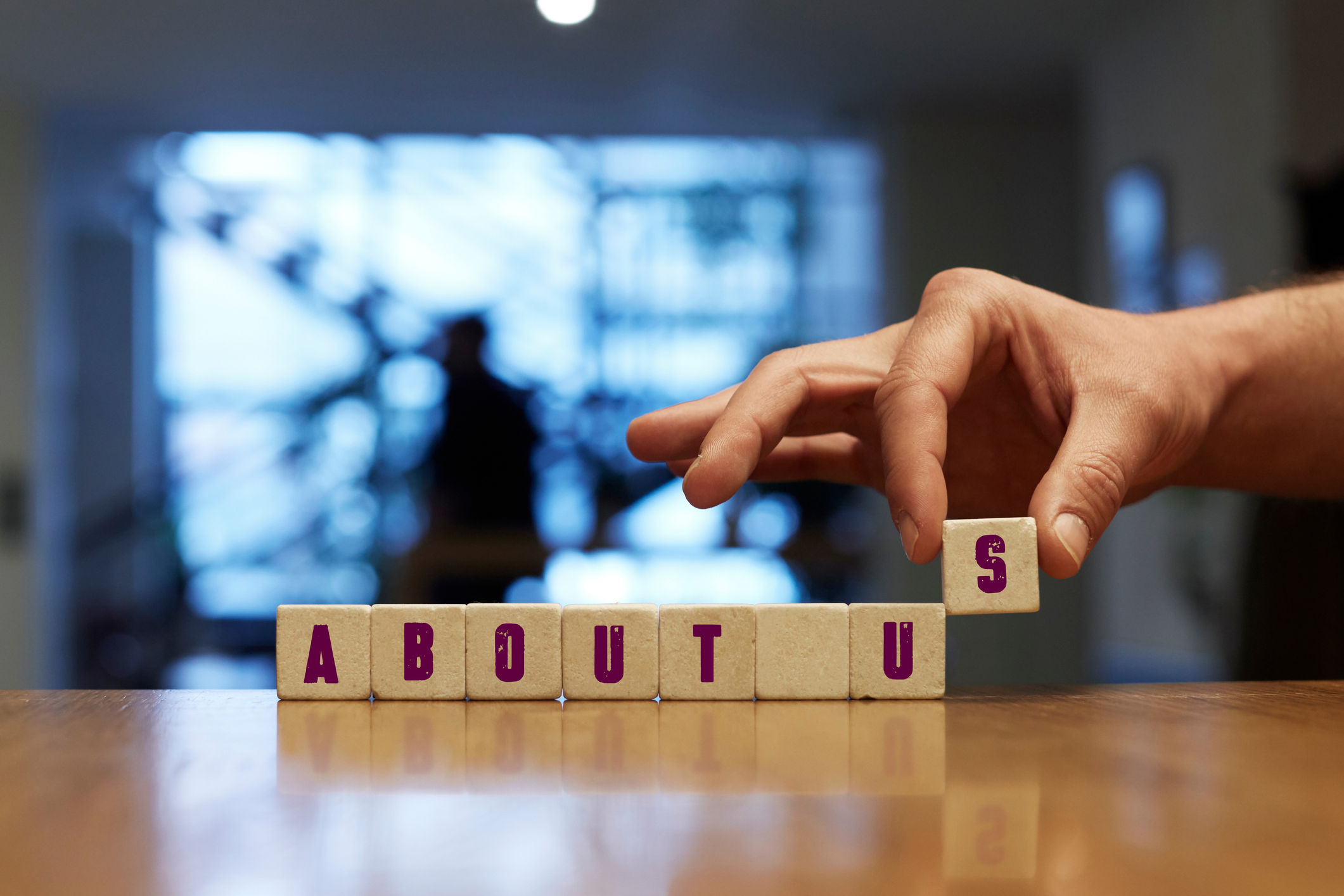 About Us Concept with Alphabet Blocks About Us Concept , Hand with alphabet blocks on wooden table